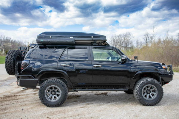 Professional overlanding gear layout including recovery equipment, storage systems, and camping esse